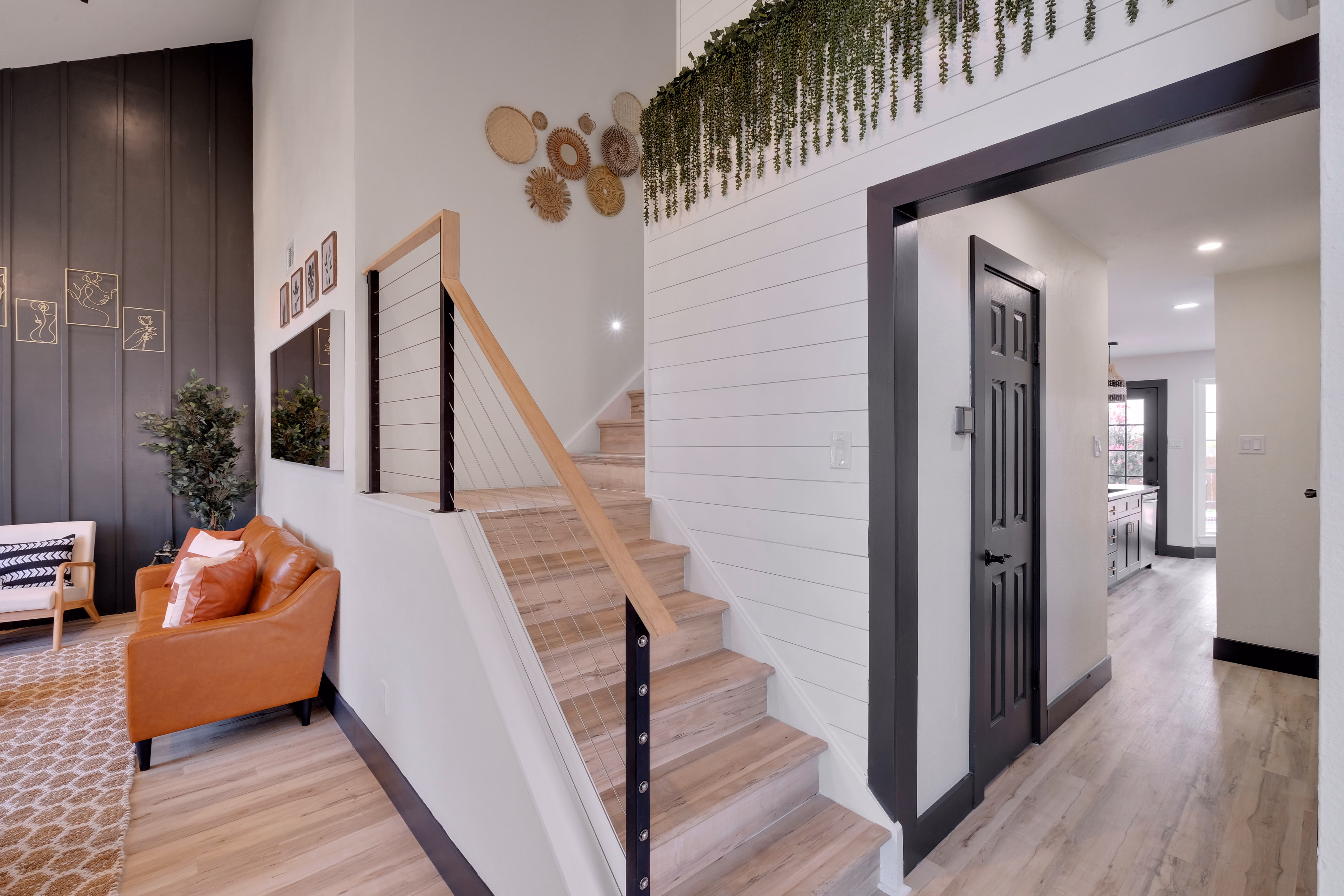 Foyer — staircase with cable rail, shiplap, view to kitchen.