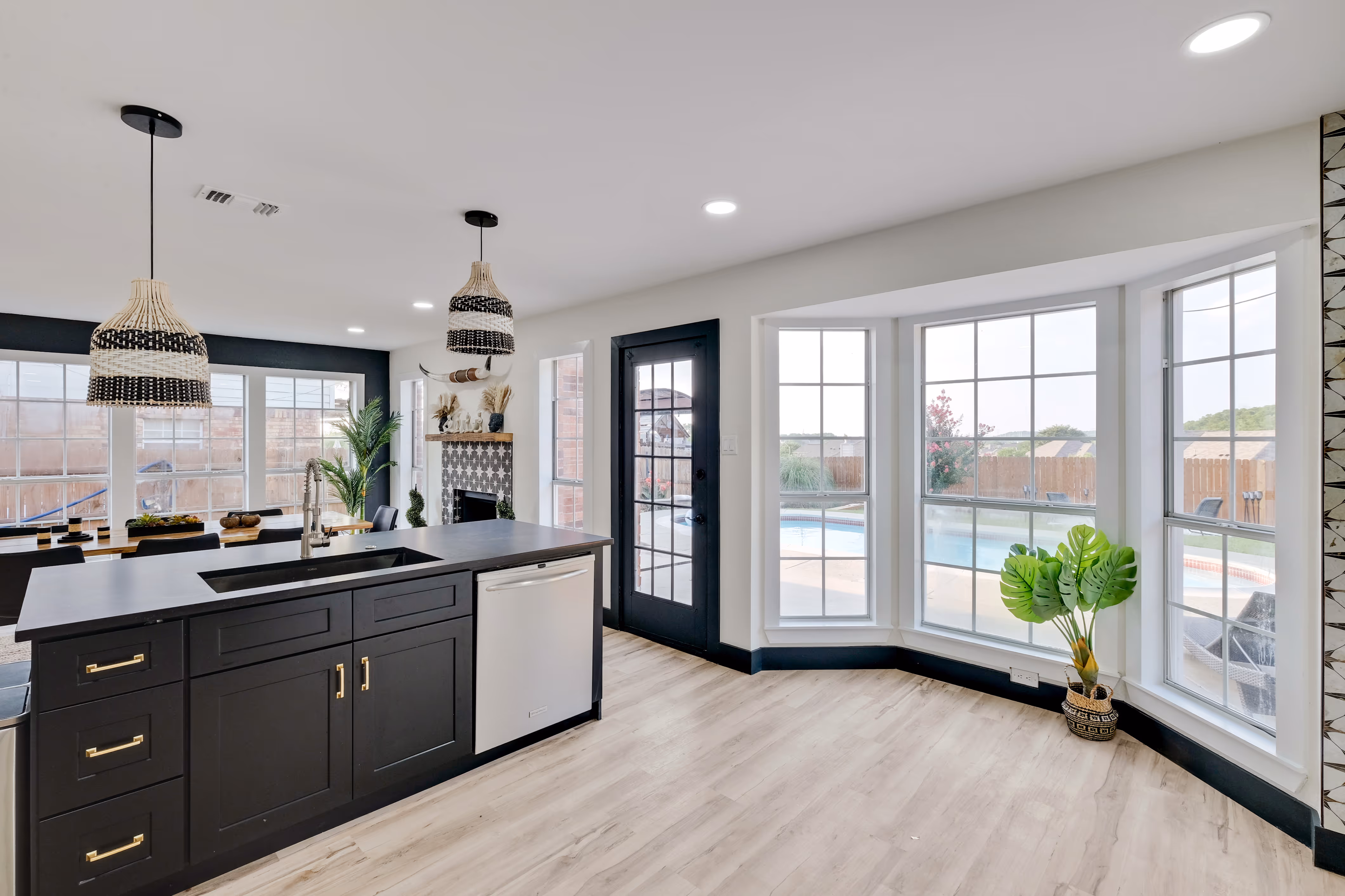Kitchen island with sink, bay window overlooking pool.
