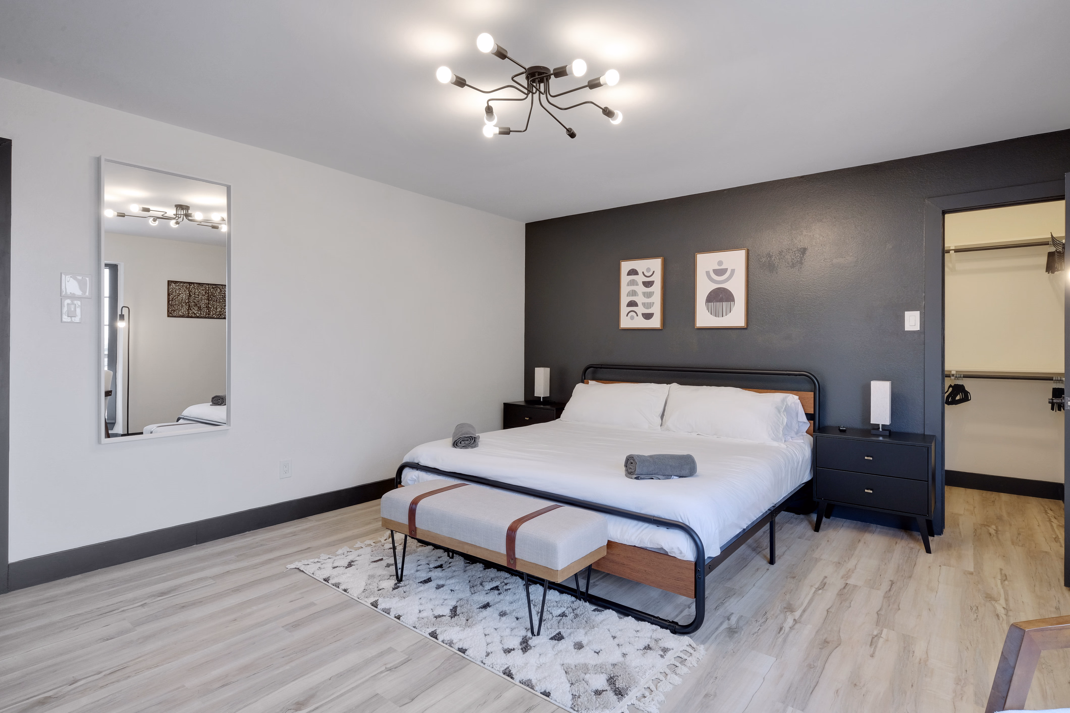 Master bedroom — king bed against dark accent wall, walk-in closet.