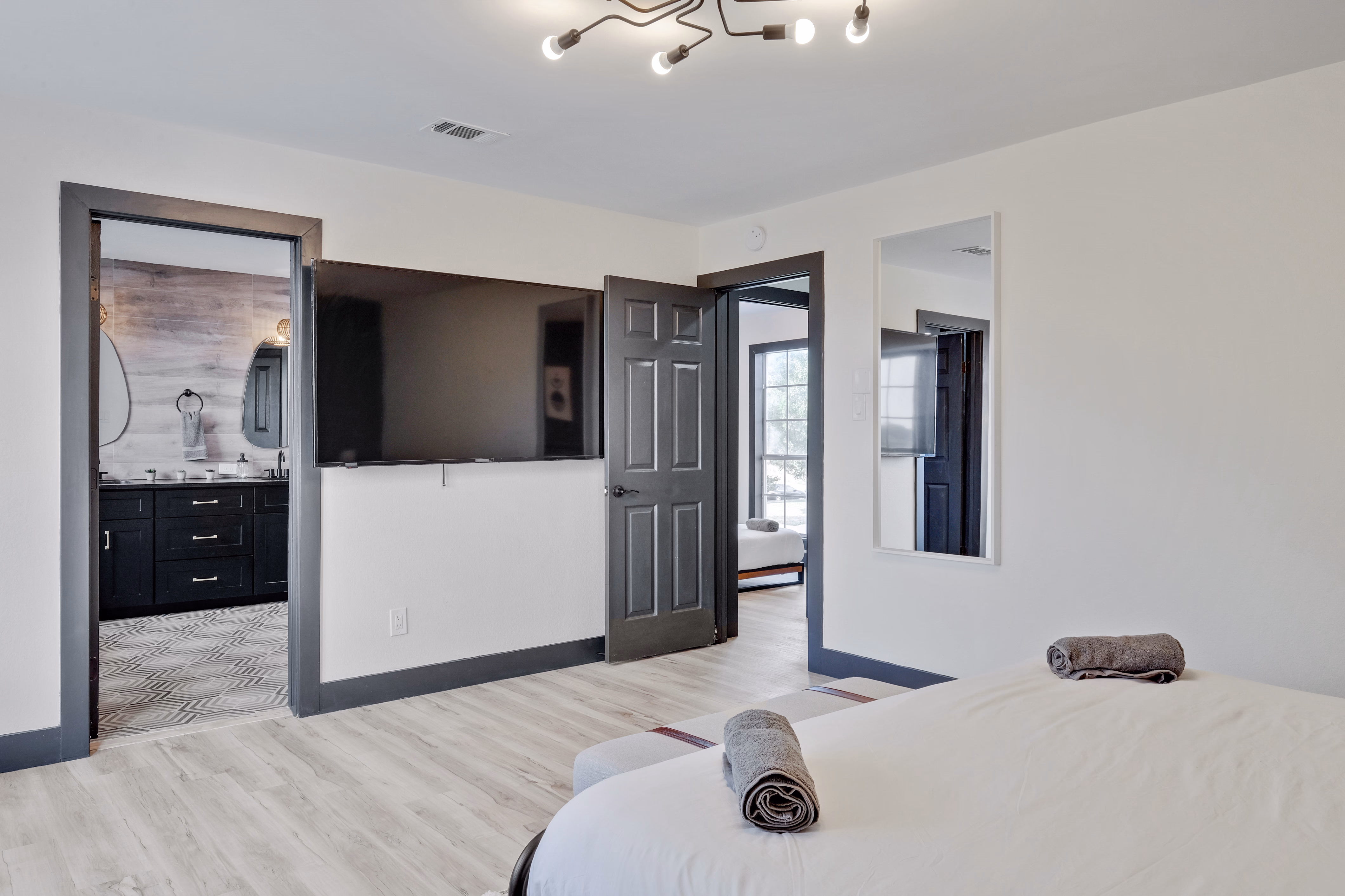 Master bedroom — TV wall, doorway into en-suite bath.