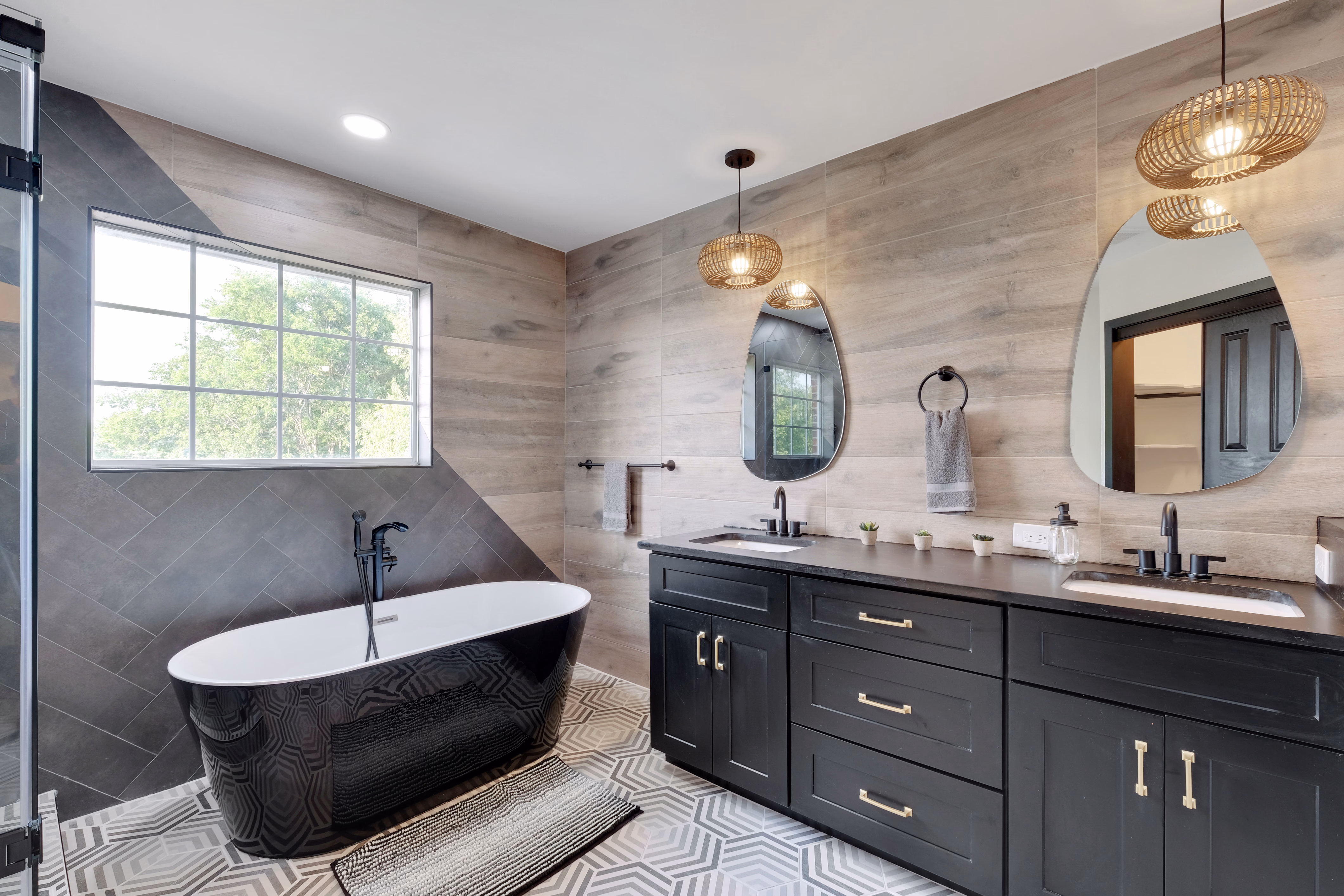 Master bath — black soaking tub, dual vanity, glass shower.