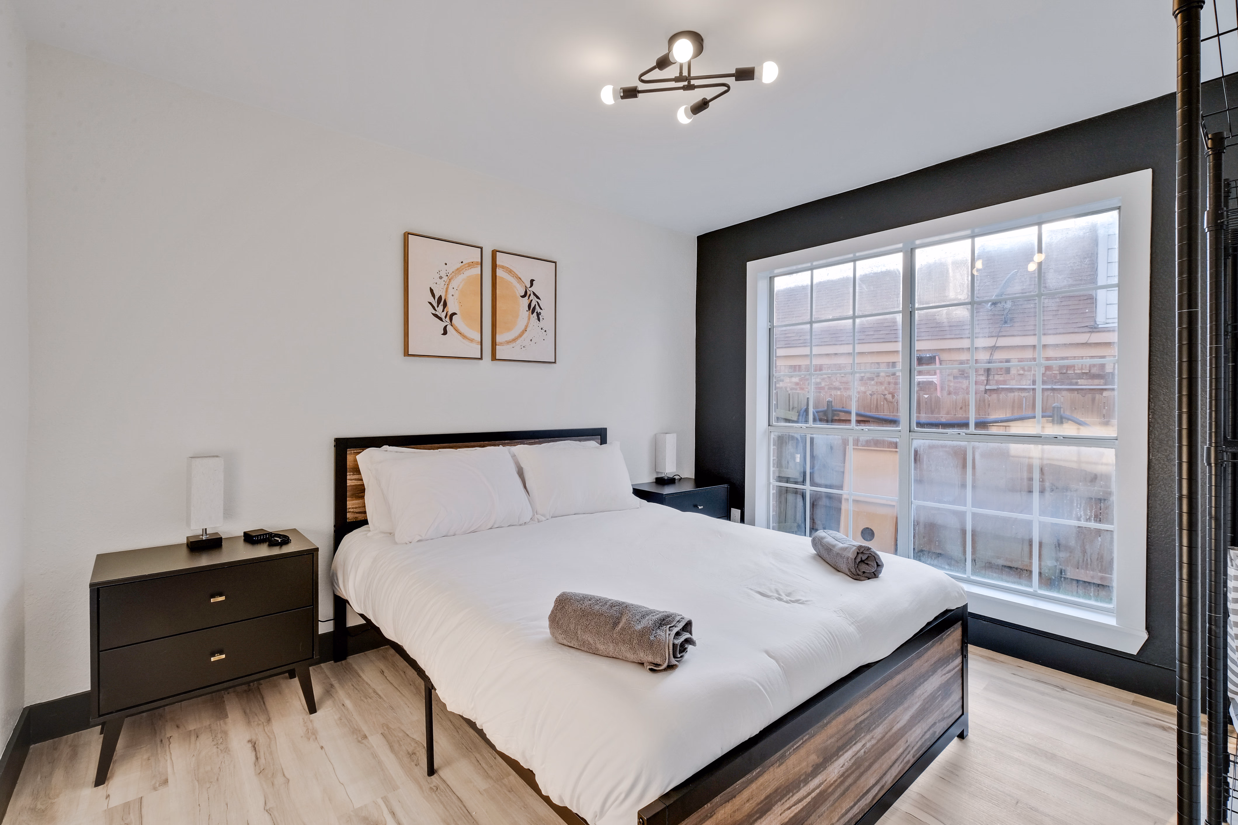 Upstairs bedroom — queen bed, sunburst art over headboard.